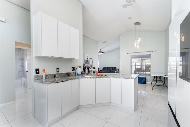 kitchen featuring white cabinetry, kitchen peninsula, sink, and hanging light fixtures