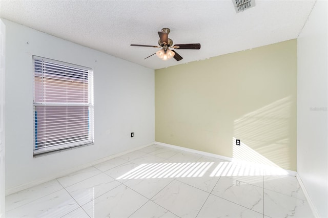 empty room featuring ceiling fan and a textured ceiling