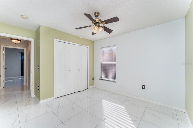 unfurnished bedroom featuring a textured ceiling, a closet, and ceiling fan