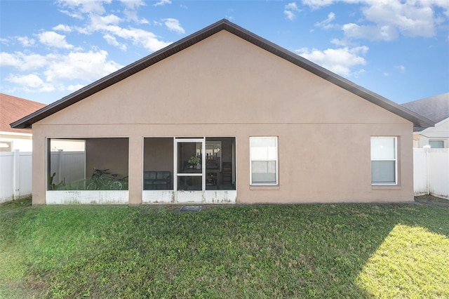 rear view of property with a lawn