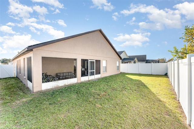 rear view of house featuring a lawn