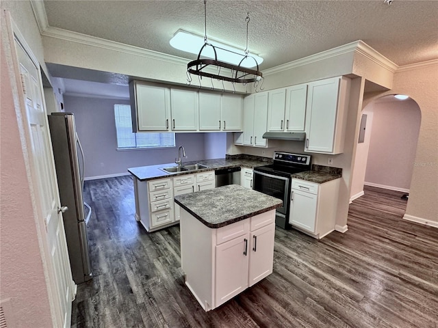 kitchen with appliances with stainless steel finishes, white cabinets, hanging light fixtures, a center island, and a textured ceiling