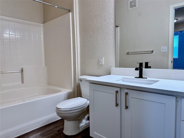 full bathroom with hardwood / wood-style flooring, shower / tub combination, vanity, and toilet