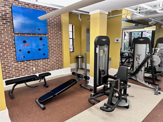 workout area featuring brick wall