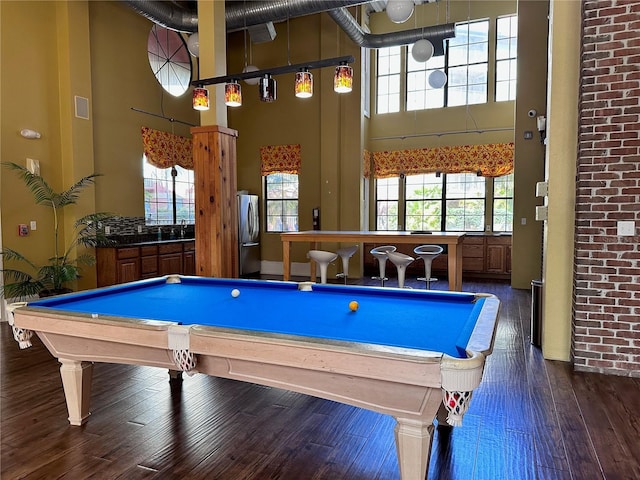 playroom featuring dark wood-type flooring, a towering ceiling, and pool table