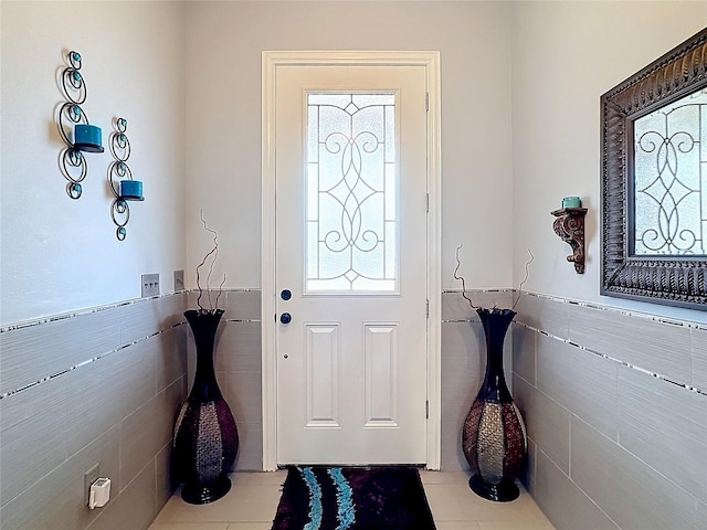 entrance foyer with light tile patterned floors and tile walls