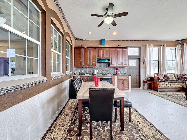 tiled dining room featuring ceiling fan and a textured ceiling