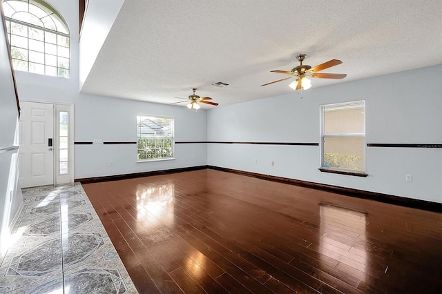 interior space featuring ceiling fan, a textured ceiling, and dark hardwood / wood-style flooring