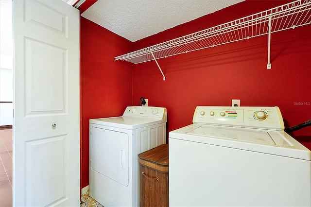 clothes washing area with washer and dryer and a textured ceiling