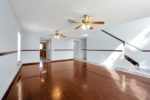 interior space featuring ceiling fan, wood-type flooring, and a textured ceiling