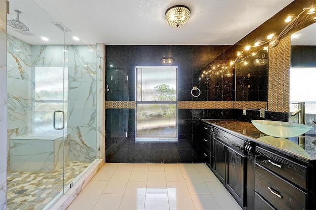 bathroom with vanity, an enclosed shower, tile patterned flooring, and tile walls