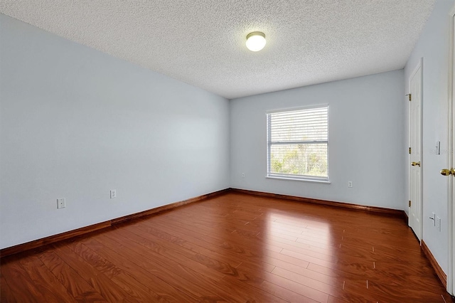 unfurnished room with dark hardwood / wood-style floors and a textured ceiling