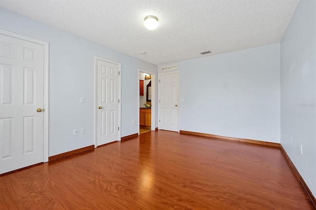 empty room featuring hardwood / wood-style floors and a textured ceiling