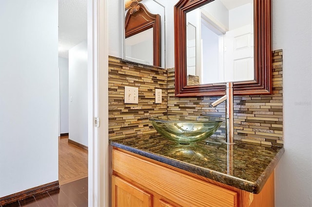 interior space featuring vanity, backsplash, and hardwood / wood-style floors