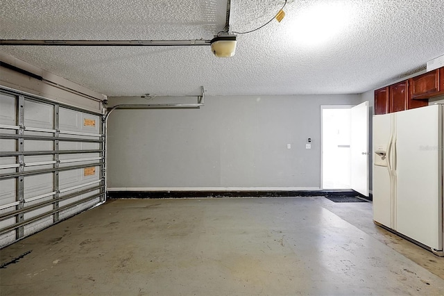 garage with a garage door opener and white fridge with ice dispenser