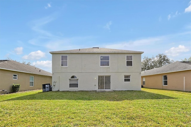 rear view of house with a yard and cooling unit