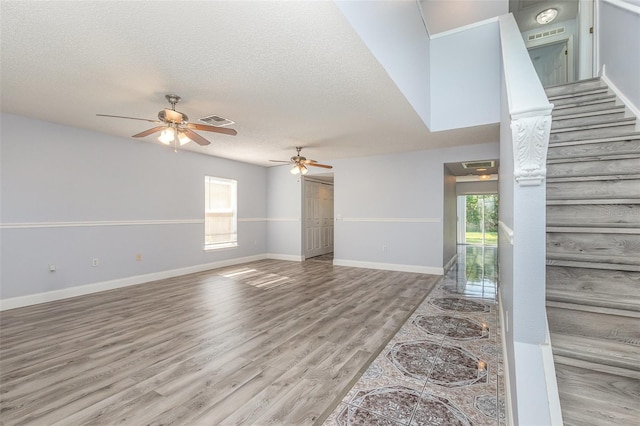 1633 Corner Meadow Cir, Orlando, FL 32820 - unfurnished living room featuring healthy amount of natural light, ceiling fan, wood finished floors, a textured ceiling, and baseboards