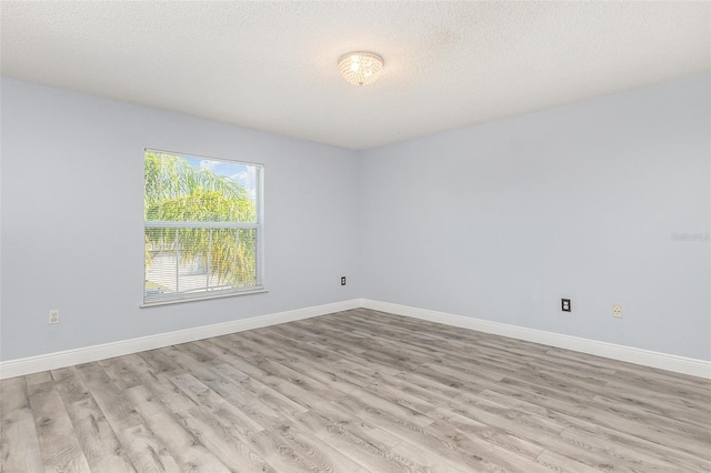 1633 Corner Meadow Cir, Orlando, FL 32820 - empty room featuring light wood-style flooring, baseboards, and a textured ceiling