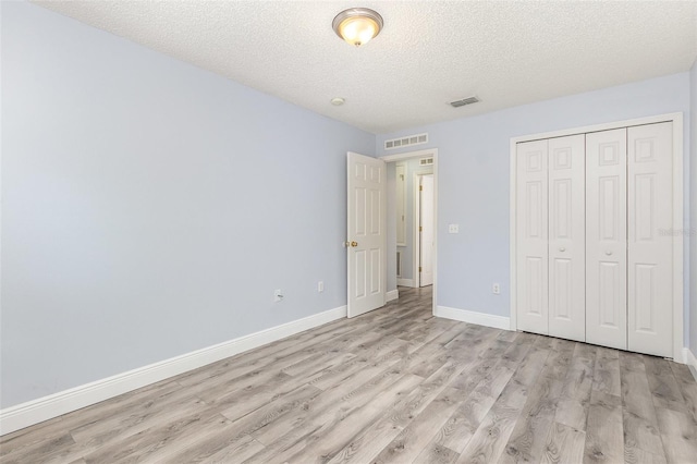 1633 Corner Meadow Cir, Orlando, FL 32820 - unfurnished bedroom featuring light wood-type flooring, baseboards, a textured ceiling, and a closet
