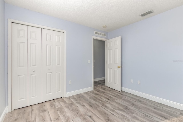 1633 Corner Meadow Cir, Orlando, FL 32820 - unfurnished bedroom with light wood finished floors, a closet, a textured ceiling, and baseboards
