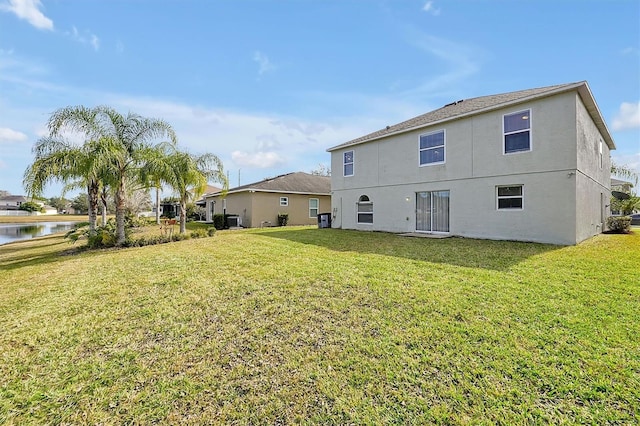 1633 Corner Meadow Cir, Orlando, FL 32820 - rear view of house with a water view, a yard, and stucco siding