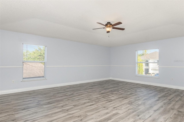 1633 Corner Meadow Cir, Orlando, FL 32820 - empty room with wood finished floors, healthy amount of natural light, a ceiling fan, a textured ceiling, and baseboards