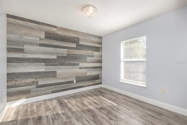 1633 Corner Meadow Cir, Orlando, FL 32820 - unfurnished room featuring wood finished floors, wood walls, baseboards, and a textured ceiling
