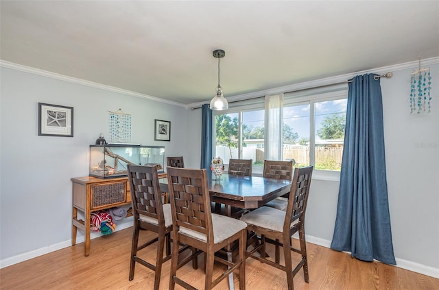 dining area featuring hardwood / wood-style flooring and crown molding