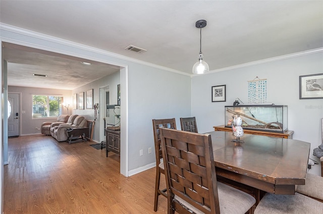 dining room featuring wood-type flooring and ornamental molding