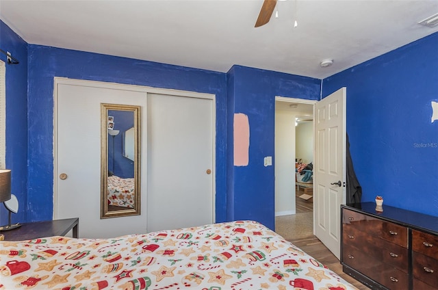 bedroom featuring hardwood / wood-style floors, a closet, and ceiling fan