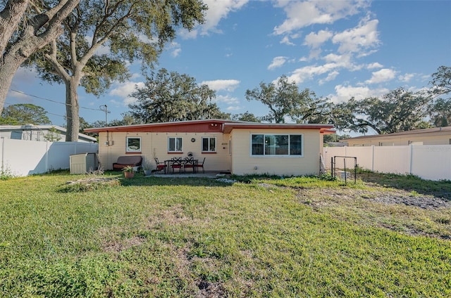 rear view of house featuring a yard and a patio area