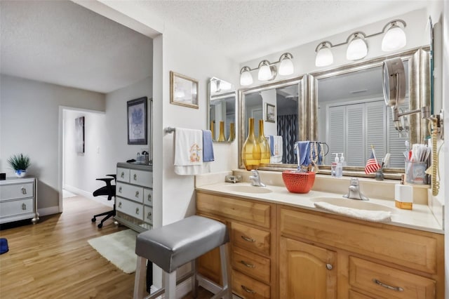 bathroom featuring vanity, wood-type flooring, and a textured ceiling