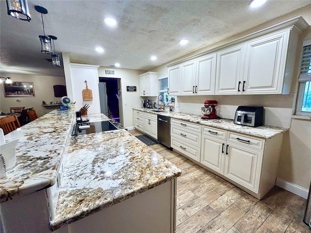 kitchen with pendant lighting, sink, dishwasher, light hardwood / wood-style floors, and white cabinets