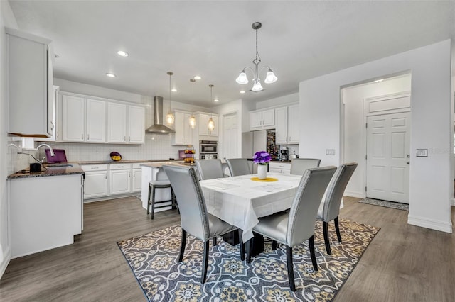 dining space featuring dark hardwood / wood-style floors, a chandelier, and sink