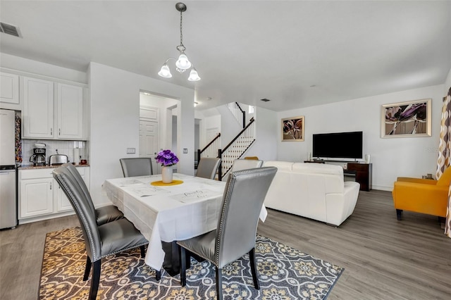 dining area with a chandelier and light hardwood / wood-style floors