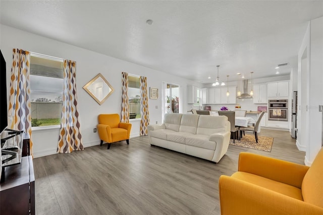 living room with light hardwood / wood-style floors and a textured ceiling