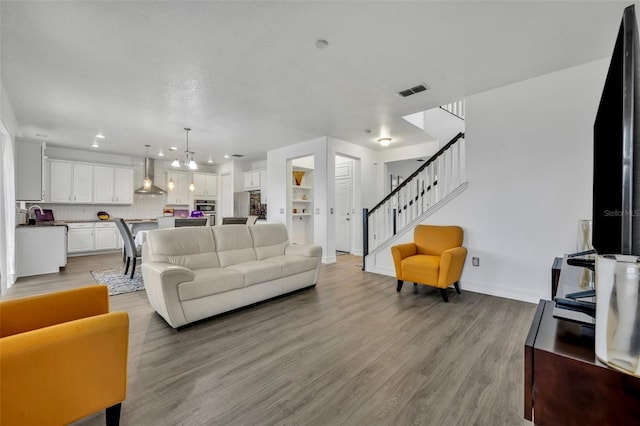 living room featuring sink and light hardwood / wood-style flooring