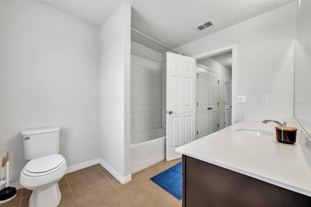 full bathroom featuring tile patterned flooring, vanity, a textured ceiling, toilet, and tiled shower / bath