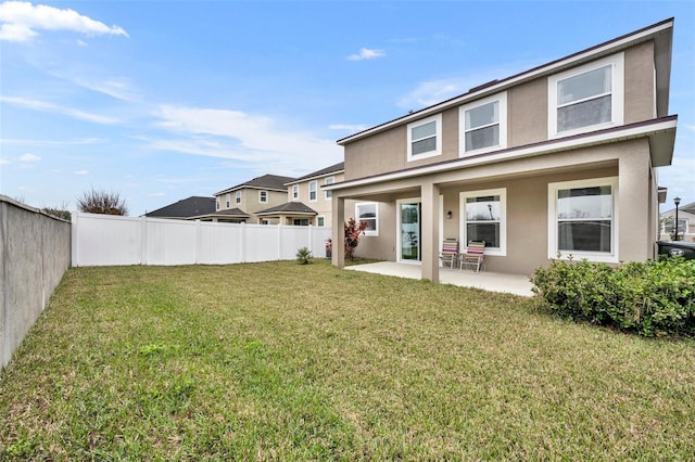 back of property featuring a patio area and a lawn