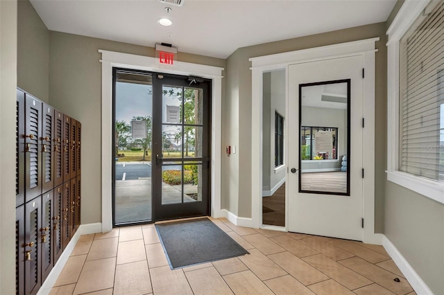 entryway with light tile patterned floors and french doors