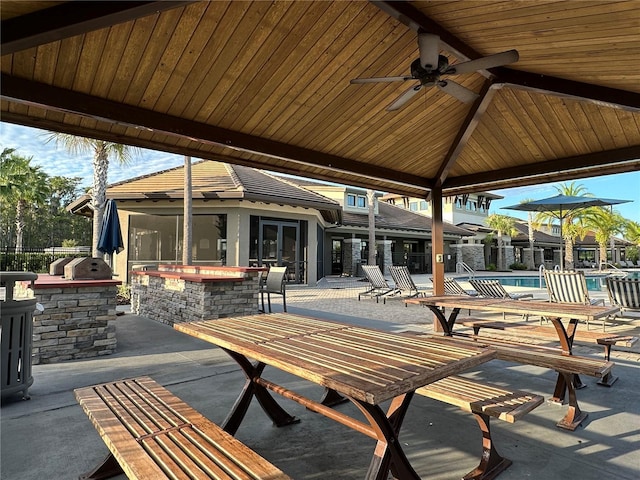 view of patio / terrace with a gazebo, exterior bar, a community pool, and ceiling fan