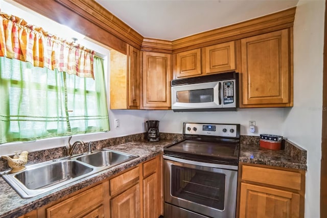 kitchen with sink, dark stone countertops, and stainless steel appliances