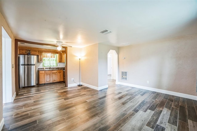 unfurnished living room with sink, ceiling fan, and dark hardwood / wood-style flooring