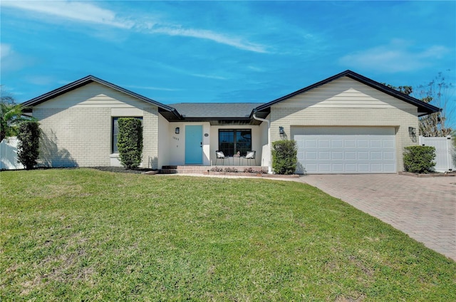 ranch-style home featuring an attached garage, brick siding, fence, decorative driveway, and a front yard