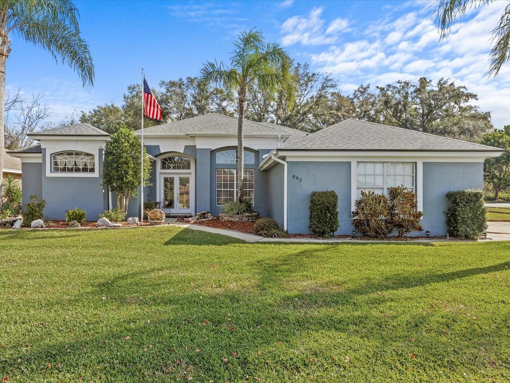 ranch-style home with a front yard and french doors