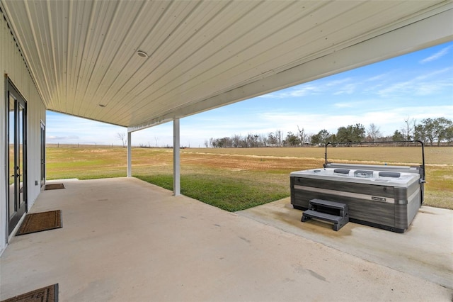 view of patio / terrace featuring a rural view and a hot tub