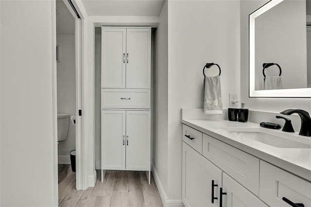 bathroom with vanity, hardwood / wood-style floors, and toilet