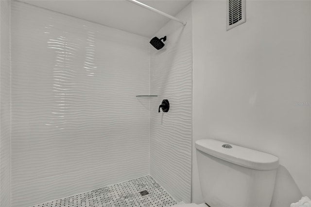 bathroom with tiled shower and toilet