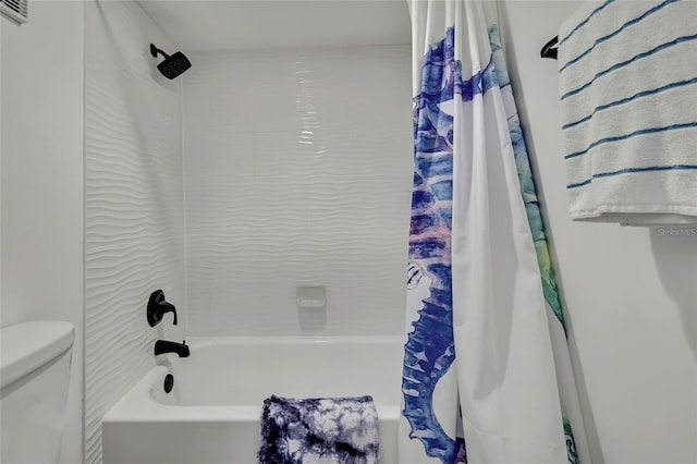 bathroom featuring shower / tub combo with curtain and toilet