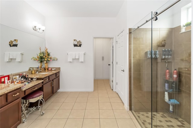 bathroom with tile patterned flooring, vanity, and walk in shower